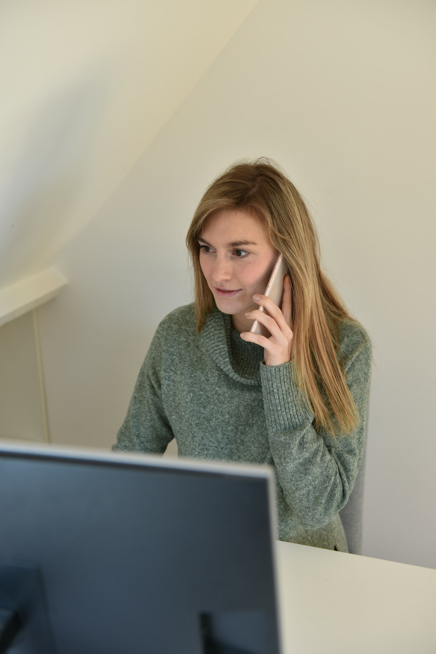 A woman on a phone call at her desk